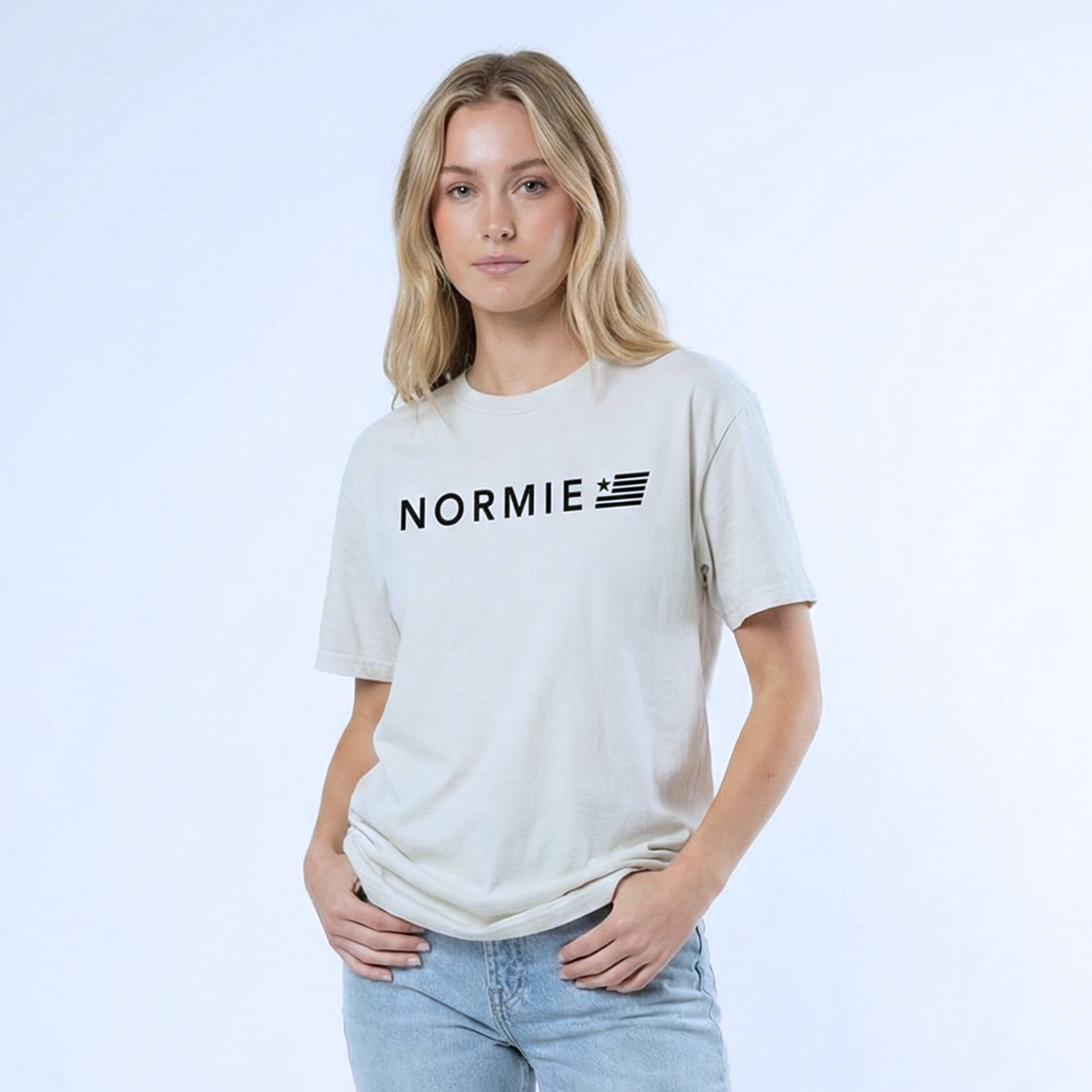 woman wearing a white t-shirt with 'NORMIE' logo on a light blue background